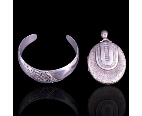 A large Victorian Etruscan Revival influenced silver pendant locket together with a cuff bangle, locket 6.5 cm including bale