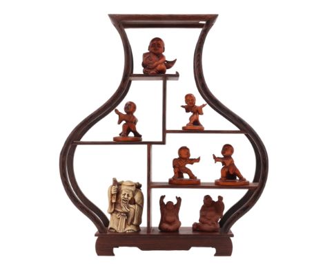 A late 20th Century carved wooden netsuke in the form of a child holding a carp together with four okimonos depicting a child