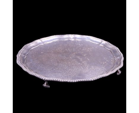 A George V large silver salver, of shaped circular form with gadrooned Chippendale rim and standing on four volute feet, C S 