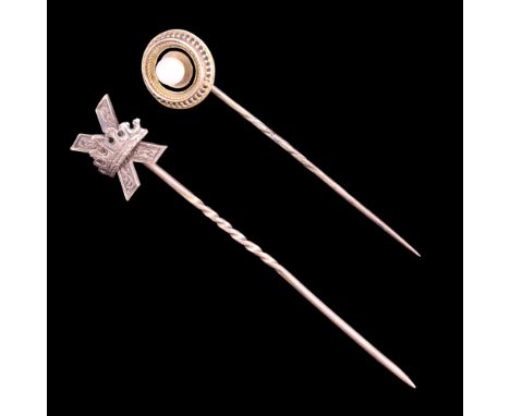 A Victorian yellow metal stick pin having a crown-and-saltire terminal, together with one other, its enamelled yellow metal t