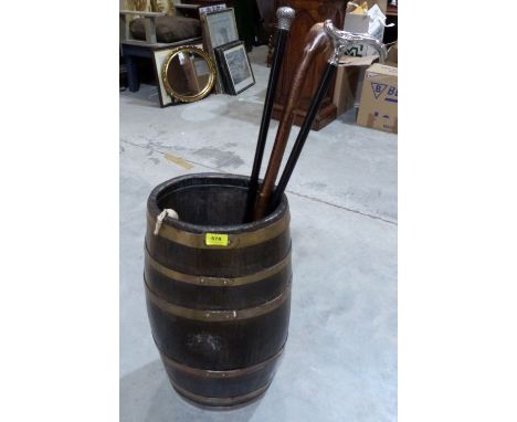 An oak and brass coopered stickstand with two walking canes and a stick