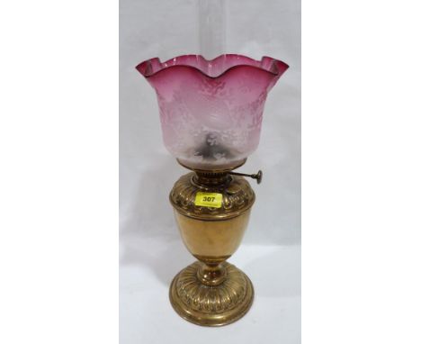 A Victorian brass oillamp with crimped ruby flashed shade and acid etched foliate decoration