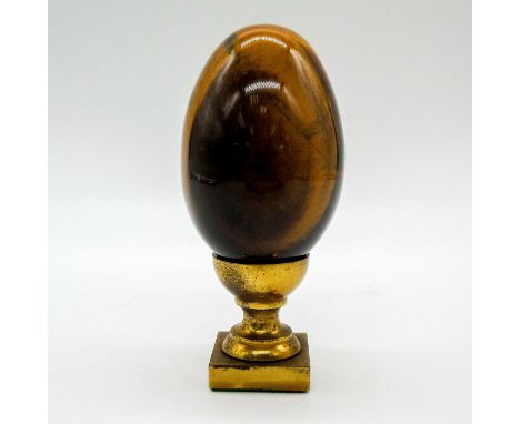 Carved polish brownish-yellow egg with a brass cup egg stand.Tigers Eye is known for healing properties to clear negative ene