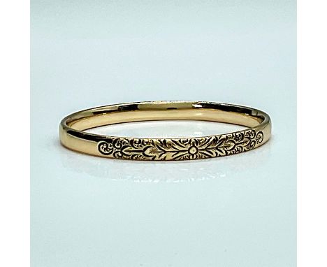 Beautifully crafted gold toned bangle engraved with whimsical curls and leaves. Substantial weight gives this piece a feel of