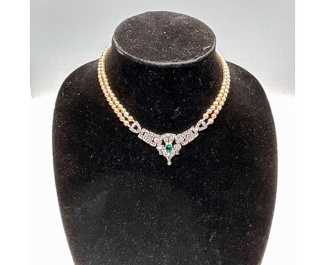 This Vintage necklace features two delicate faux-pearl strands completed with a central emerald-like cabochon and crystal sto