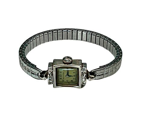 Exquisite wind-up timepiece from Bulova, crafted from 14K white gold in an Art Deco style. Face is shaped like a gift box cro