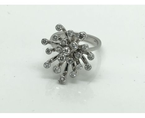 A Modern design Abstract platinum and diamond ring, set with a star burst of elenven brilliant cut diamonds, possibly E/F col