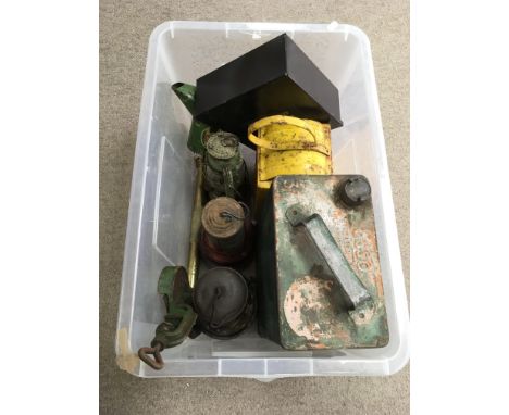 A collection of old oil lamps, petrol cans and tools