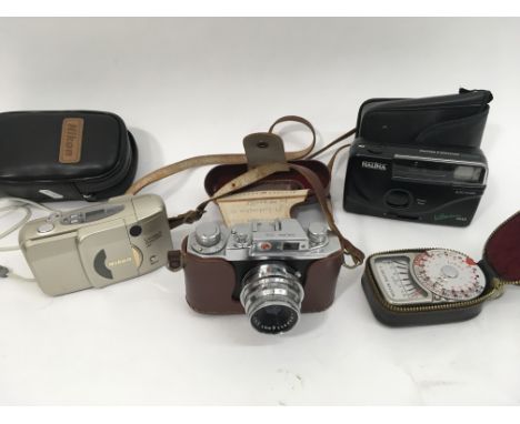 A Halina Anastigmat camera and lens, a Weston light meter, a Halina Vision instamatic camera, and a Nikon lite touch instamat