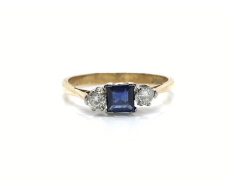 An 18ct gold engagement ring set with a square sapphire flanked by diamonds. Approx size O, total weight approximately 2.3 gr