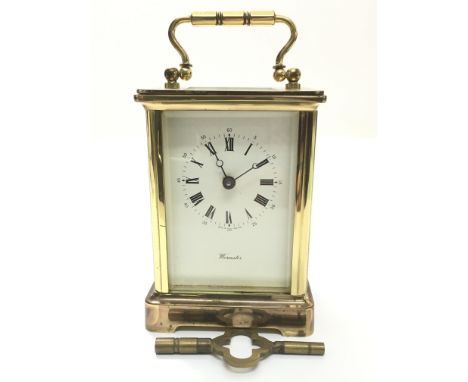 A small French brass carriage clock with both Roman and Arabic numerals, with key, approximate height 11cm.