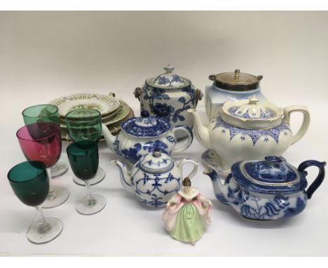 A collection of ceramic and glass items including two biscuit barrels, a small Doulton figure, four teapots, wall plates and 