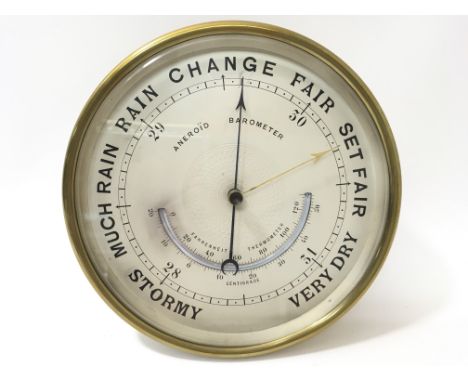 A circular brass cased aneroid barometer, diameter approximately 17.5cm.