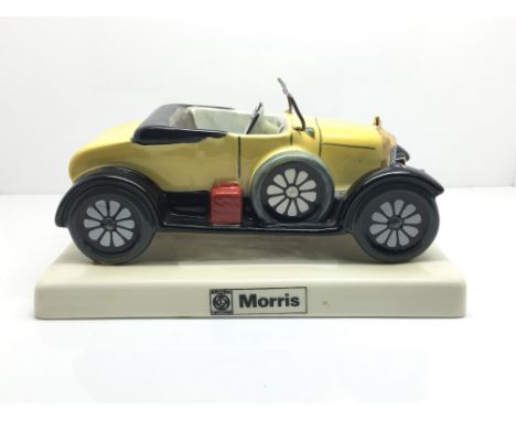 A Carltonware bull nose yellow Morris car on a base encribd Morris, number plate BW 711.