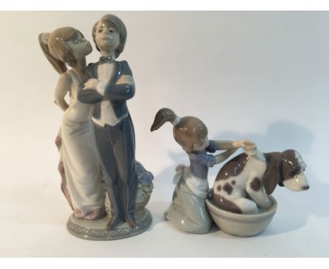 Two Lladro figures; a girl with a dog and first kiss.