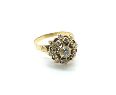 An unmarked gold and diamond cluster ring of floral influence, lacking one stone. Approx size N, total weight approximately 3