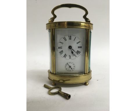 An oval brass carriage clock.