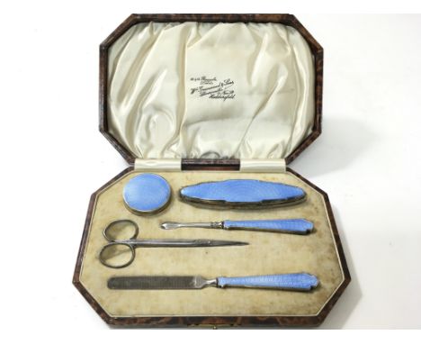 A cased silver and blue enamel manicure set, hallmarked Birmingham 1936, maker W N Ltd, to include a mirrored pot, file etc.