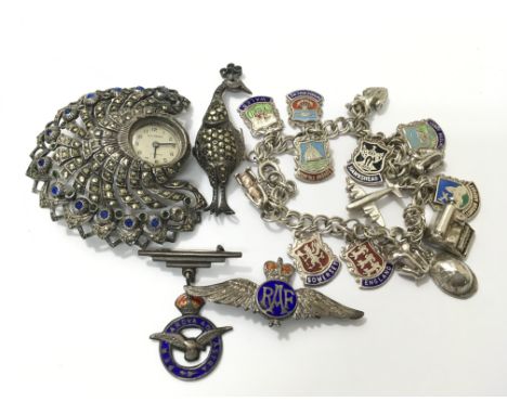 A ladies vintage marcasite peacock shaped Bucherer brooch watch inset with blue and green stones (damaged), a silver charm br