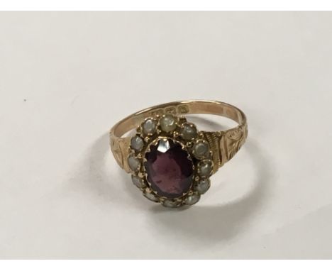 An Antique 9ct gold ring set with an oval cut amethyst surrounded by seed pearl. Marks for Birmingham. With a folate bright c