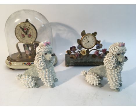 Two clocks and a pair of ceramic dogs.