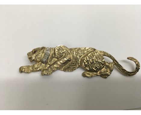 A 9ct gold brooch in the form of a tiger with ruby eyes. Weight approx 10g