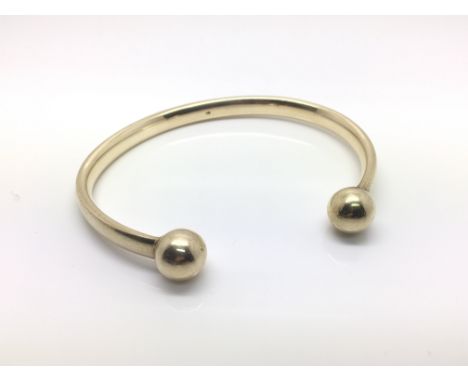 A 9ct yellow gold torque bangle, approximately 33 grams.