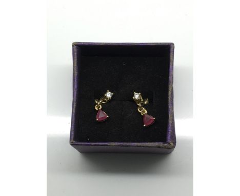 A pair of yellow metal stud earrings set with ruby and white stone drop