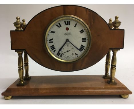 A zenith clock in a satinwood case. The movement with unusual wind indicator.