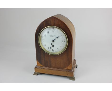 An Edwardian mahogany lancet shaped mantel clock white enamel dial, marked Camerer, Kuss &amp; Co, 186 Uxbridge Road, Shepher