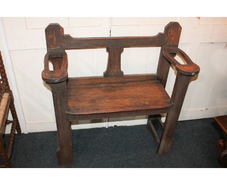 An early 20th century oak hall bench with arms as stick holders, 81cm