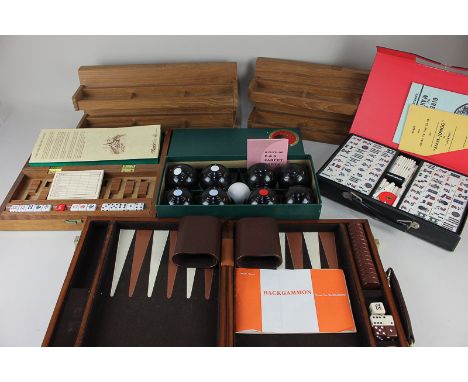 A collection of games including Mahjong with wooden racks, Backgammon, Carpet Bowls, and a sailor's dice set, all boxed