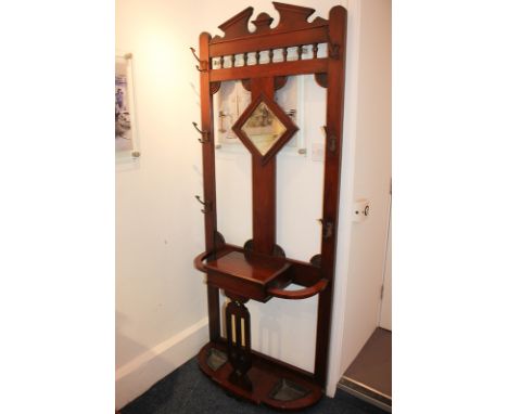 A Victorian mahogany hall stand with broken arch pediment, central mirror and glove box, on base with stick stands and trays,