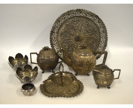 An Indian low grade metal three-piece tea service with floral chased decoration, to/w a somewhat similar trefoil petit fours 