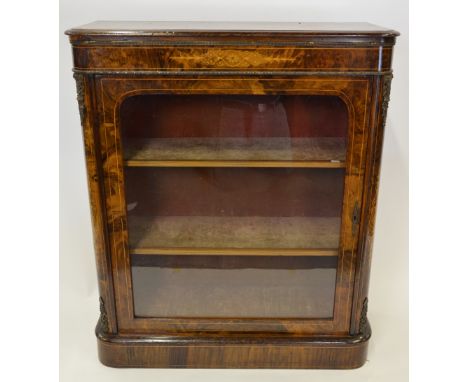 A Victorian ormolu mounted walnut pier cabinet, the single arch glazed panel door enclosing shelves to a fabric lined interio