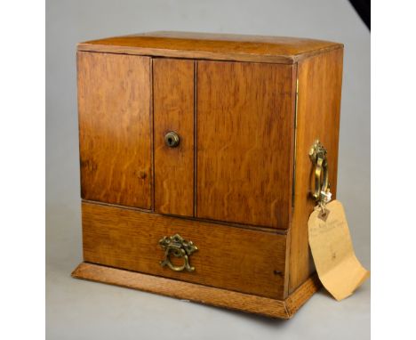 A Victorian light oak smokers cabinet with fitted pipe rack, matchbox holder and three drawers