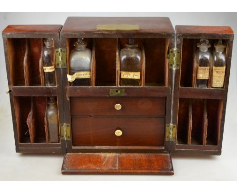 An early 19th century mahogany travelling apothecary's box, fitted with shelves, drawers and a concealed rear compartment, al