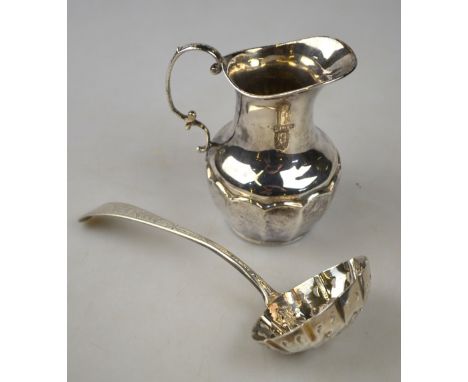 A silver 'berry' sifter ladle of Georgian origin with embossed and pierced bowl, to/w an Edwardian cream jug with scroll hand