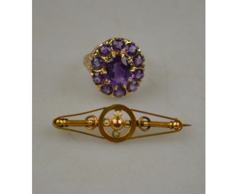 An oval amethyst cluster ring, 9ct yellow gold cast claw setting with engraved shoulders, size O 1/2 to/w pierced elliptical 