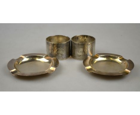 A pair of heavy quality engine-turned napkin rings, S Blackensee & Sons Ltd, to/w a pair of silver ashtrays, all Birmingham 1
