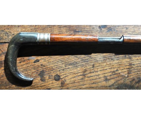 A Dumonthier .410 gauge walking stick shotgun with horn handle and revolving nickel trigger-guard, the rosewood shaft contain