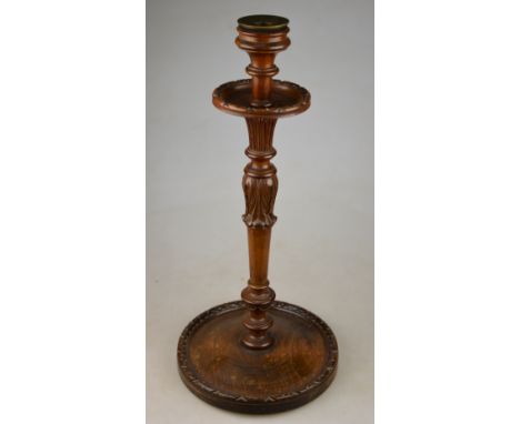 A turned and carved candlestick to/w a circular pipe rack incorporating a lidded tobacco store c/w three pipes (5)