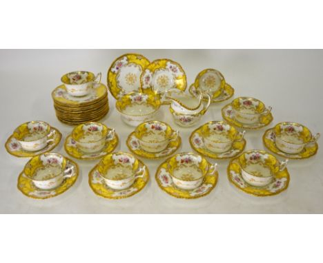 A Coalport china tea service, yellow and gilt with floral sprays comprising twelve side plates, twelve saucers, twelve tea cu