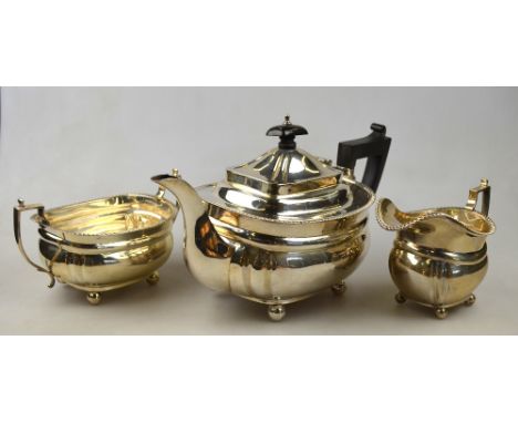 An oblong silver three-piece tea service with gadrooned rims and ball feet, Elkington & Co, Birmingham 1919, 30.5 oz gross