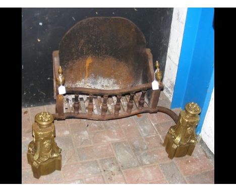 A decorative antique fire grate with ornate brass dogs 