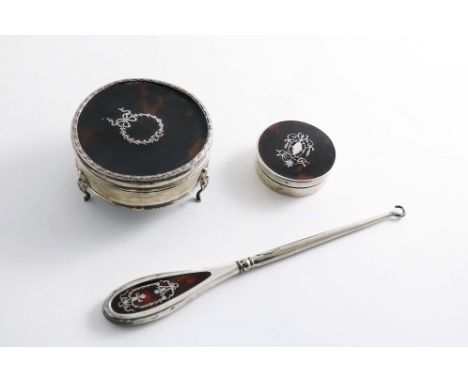 AN EARLY 20TH CENTURY CIRCULAR DRESSING TABLE BOX on three legs with an inlaid tortoiseshell cover, by H. Matthews, Birmingha