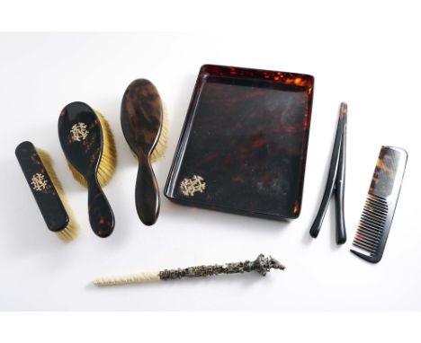 A LATE VICTORIAN TORTOISESHELL, PART DRESSING TABLE SET TO INCLUDE:- a tray and two brushes, each with an applied gold monogr