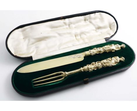 A VICTORIAN CASED SILVERGILT DESSERT SERVING KNIFE AND FORK the handles modelled in the form of a classical maiden adorned wi