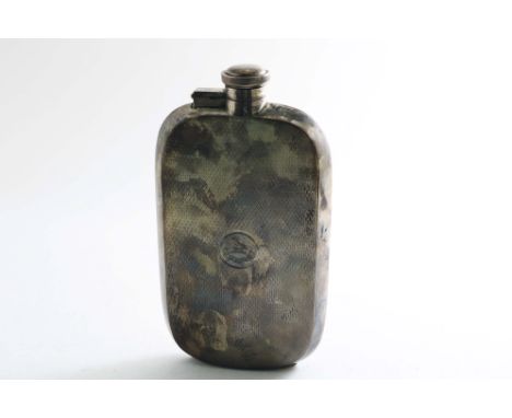 AN EARLY 20TH CENTURY SPIRIT FLASK of rounded oblong form with engine-turned decoration, engraved with a crest &amp; motto, b