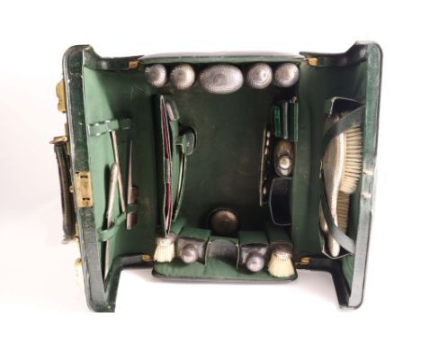 AN EDWARDIAN GREEN LEATHER GENTLEMAN'S DRESSING CASE fitted with the following silvergilt mounted items with a plannished fin